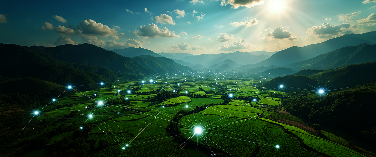 Üppige terrassierte Felder erstrecken sich durch ein Tal, umrahmt von Bergen, von der Sonne bestrahlt. Über den Feldern ziehen leuchtende Punkte und Verbindungen, die eine digitale Netzstruktur darstellen und smarte Landwirtschaft sowie Konnektivität symbolisieren.