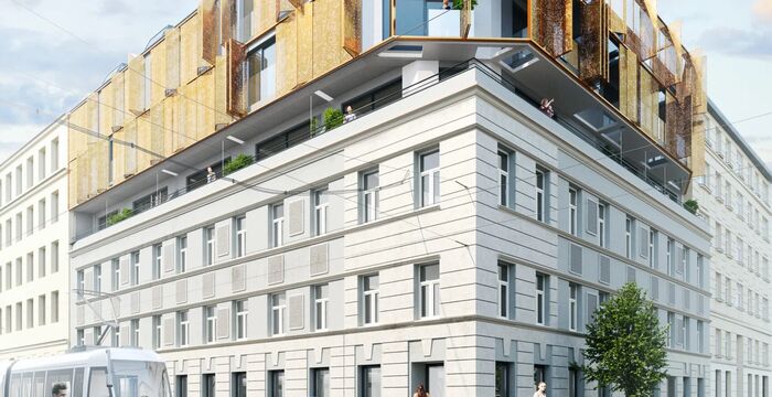 Mehrstöckiges Straßengebäude mit heller Steinfassade im unteren Teil und moderner gelb-brauner Metallverkleidung am Dachgeschoss; Straßenszene mit Straßenbahn, Auto, Fahrrad und Fußgängern; Baum am Gehweg.