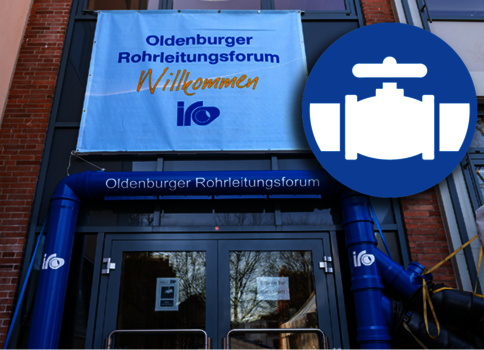 Außenaufnahme eines Gebäudes mit Eingang. Ein blaues Willkommensbanner des Oldenburger Rohrleitungsforums hängt über der Tür, daneben ein sichtbares blaues Rohrleitungssystem. Oben rechts prangt ein großes blaues Rundsymbol mit einem weißen Ventil-Symbol.