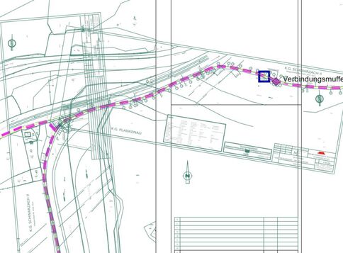 Lageplan eines Baugeländes mit einer kurvenreichen, magentafarbigen, gestrichelten Rohrleitungsführung, die eine Straße kreuzt. Ein blaues Quadrat markiert eine Verbindungsstelle (Verbindungsmuffe). Contourenlinien, Beschriftungen und Tabellen sind im Plan dargestellt.