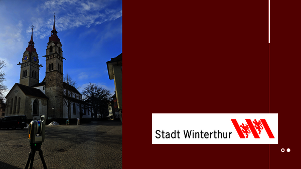 Zwei spitz zulaufende Kirchtürme einer Stadtkirche ragen in den blauen Himmel, umgeben von einem gepflasterten Platz. Im Vordergrund steht ein Parkautomat. Rechts ein roter Banner mit dem weißen Logo 'Stadt Winterthur'.