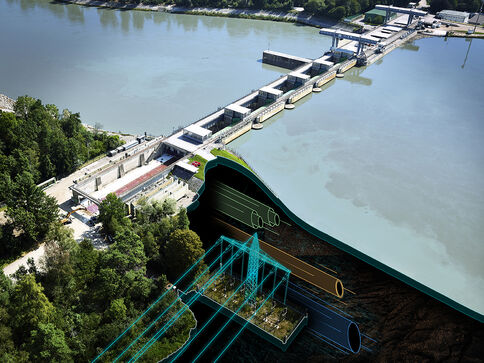 Luftaufnahme eines Fluss-Sperrwerks: Mehrere Schleusenkammern ziehen sich am Ufer entlang; ein großes, grünes Stauwehrtor dominiert, bunte Rohre liegen im Vordergrund; Wald umgibt die Anlage.