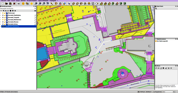 Capture d'écran d'un logiciel de plans (CAD/SIG) montrant un plan d'aménagement urbain: zones colorées identifiant bâtiments violet, espaces verts vert, zones techniques jaune, et réseaux/piétons grisés; au centre, une place entourée de structures et d'allées.
