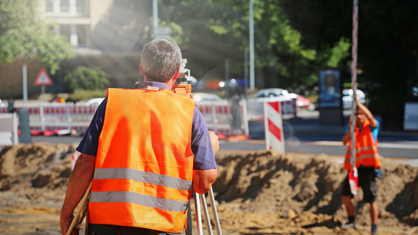 Bauvermessung Vermesser am Messgerät auf einer Baustelle