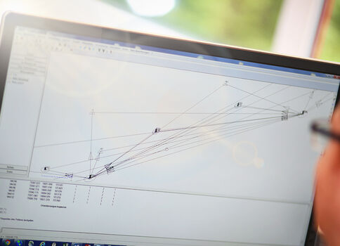 Écran d’un ordinateur portable affichant un diagramme réseau dans un logiciel de modélisation, avec de nombreuses lignes reliant des nœuds et une interface utilisateur en arrière-plan.