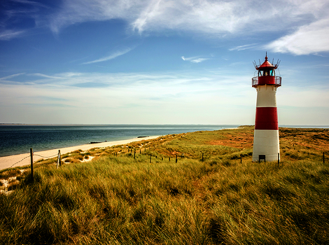 Rot-weisser Leuchtturm am Strand 