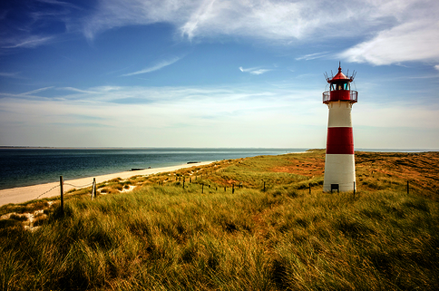 Rot-weisser Leuchtturm am Strand 