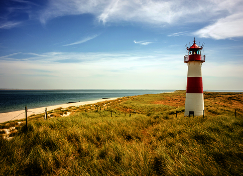 Rot-weisser Leuchtturm am Strand 