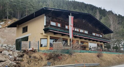 Auf dem Bild ist ein altes, zweistöckiges Haus mit Balkon zu sehen.