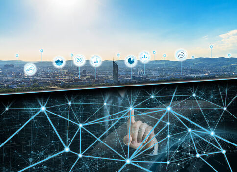 Eine Hand berührt ein leuchtendes, vernetztes Datennetz aus Knoten und Linien, das über einer Stadtlandschaft schwebt und den digitalen Verbindungsaufbau symbolisiert.