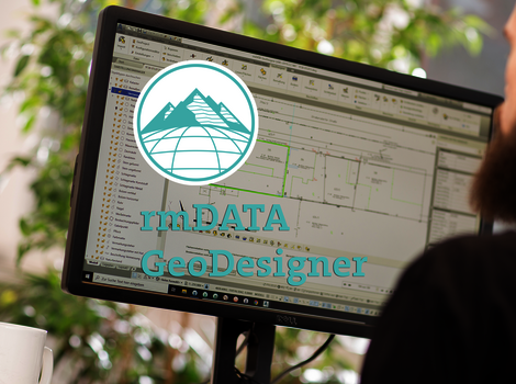 Écran d’ordinateur affichant un logiciel GIS avec des plans et données géographiques; un logo turquoise représentant des montagnes et une sphère apparaît, portant le texte "rmDATA GeoDesigner".