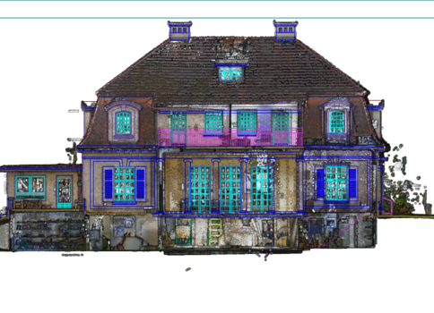 A large, decorative two-story house with a steep dark roof, several dormer windows, and bright blue window frames. The façade shows a central entry and a stone foundation, giving an ornate, symmetric residential building appearance.