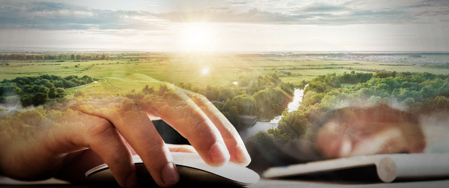 Des mains tapant sur un clavier, surimprimé par une vue de campagne verdoyante et un soleil à l'horizon, suggérant le travail à distance et la connexion entre technologie et nature.