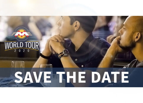 Zwei Männer sitzen nebeneinander an einem Tisch, schauen nach vorn; im Vordergrund ein Banner mit der Aufschrift "SAVE THE DATE" und dem Logo "World Tour 2020".