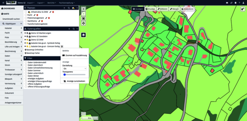 Screenshot eines GIS-Programms: Kartendarstellung eines Dorfes mit roten Gebäuden, grauen Straßen und grün gefärbtem Gelände. Links befinden sich Layer- und Menüoptionen, oben eine Symbolleiste; die Karte zeigt Straßenverläufe und Gebäudekomplexe.