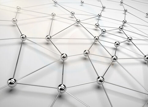 Ein dreidimensionales Netz aus silbernen Metallkugeln, die durch dünne Stäbe verbunden sind, bildet ein geometrisches Gitter.