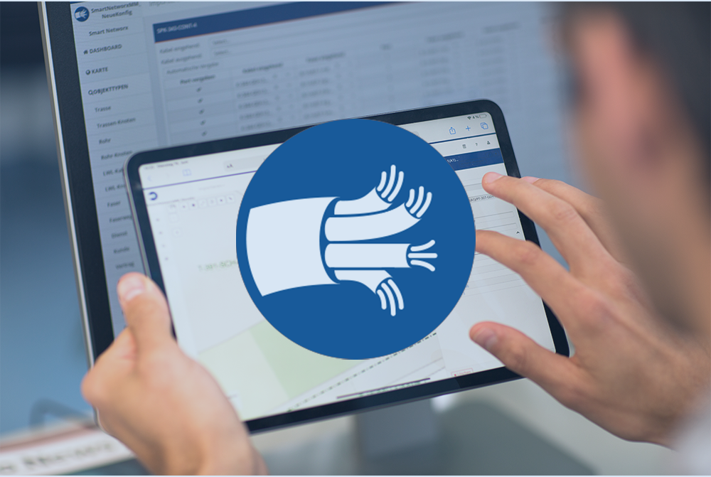 Eine Person hält ein Tablet. In der Mitte des Tablets ist ein großer blauer Kreis mit einem weißen Symbol aus drei gebündelten Kabeln zu sehen. Im Hintergrund ist ein Laptop-Bildschirm mit unscharf sichtbaren Tabellen und Diagrammen.