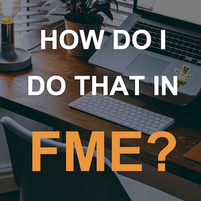 Arbeitsplatz mit Laptop, weißer Tastatur und Pflanze auf einem Holztisch; links steht eine Lampe.